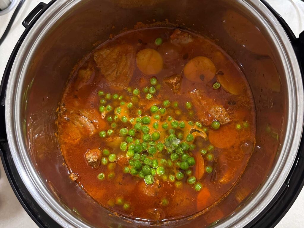 Adding green peas to my father's beef sarciado